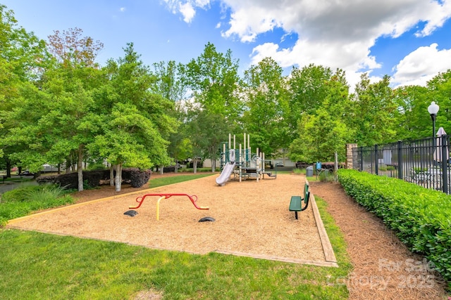 community jungle gym with view of wooded area