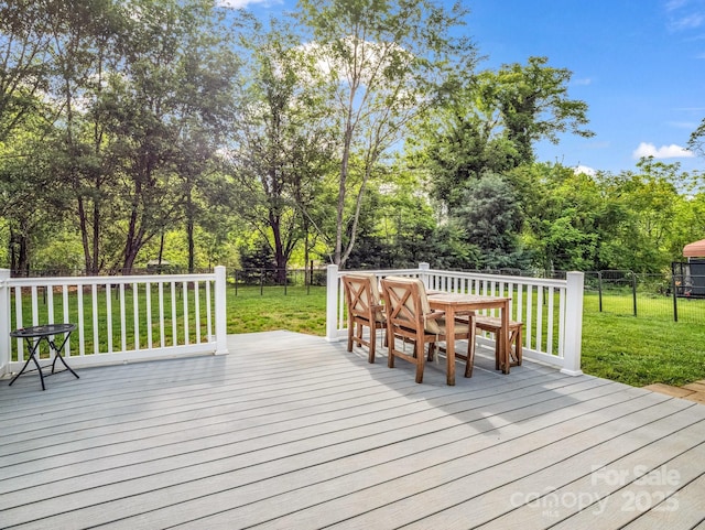 wooden terrace featuring a fenced backyard, outdoor dining area, and a yard