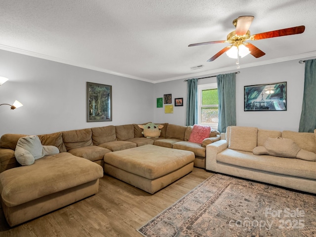 living area featuring light wood-style floors, a textured ceiling, ornamental molding, and ceiling fan