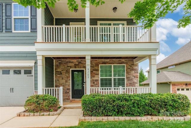 view of front of home with a porch, a balcony, and stone siding