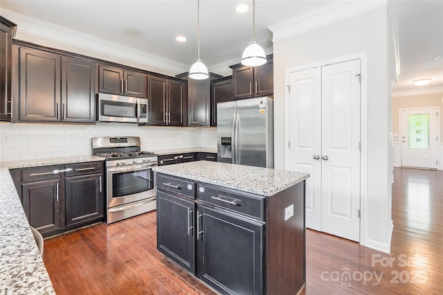 kitchen featuring ornamental molding, dark wood finished floors, appliances with stainless steel finishes, and decorative backsplash
