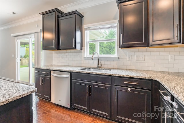 kitchen featuring crown molding, tasteful backsplash, stainless steel dishwasher, hardwood / wood-style flooring, and a sink