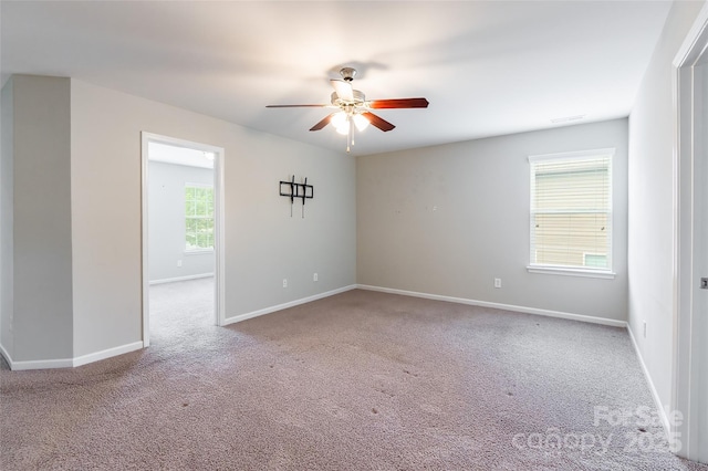 carpeted empty room with baseboards and a ceiling fan