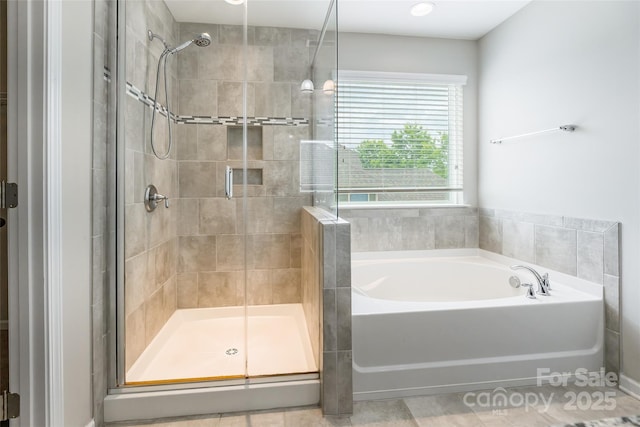 bathroom featuring a shower stall and a garden tub