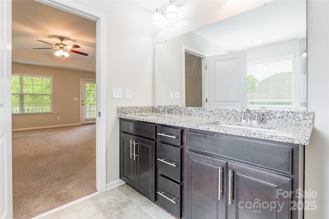 bathroom featuring baseboards, a sink, ceiling fan, and double vanity