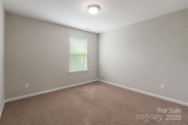 carpeted empty room with baseboards