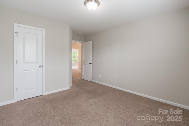 unfurnished bedroom featuring carpet floors and baseboards