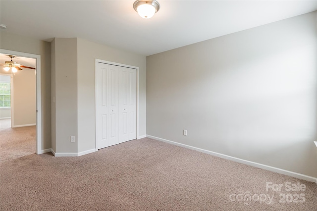 unfurnished bedroom with carpet floors, baseboards, and a closet