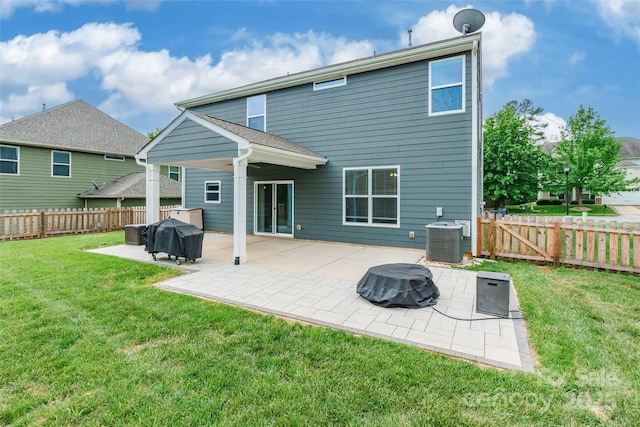 rear view of property with a fenced backyard, a gate, central AC unit, a patio area, and a yard
