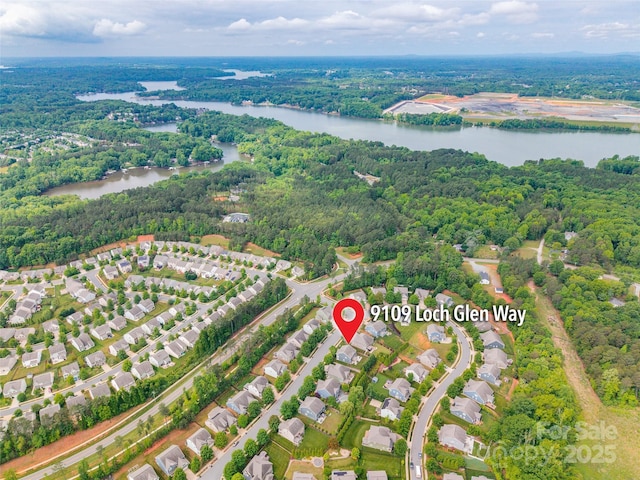 drone / aerial view with a water view and a view of trees