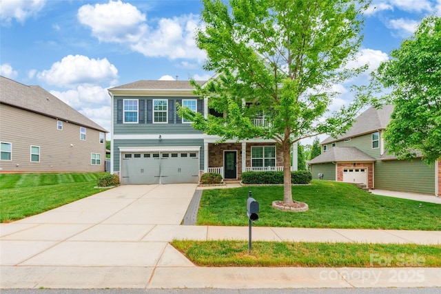 craftsman house with a garage, covered porch, concrete driveway, and a front yard