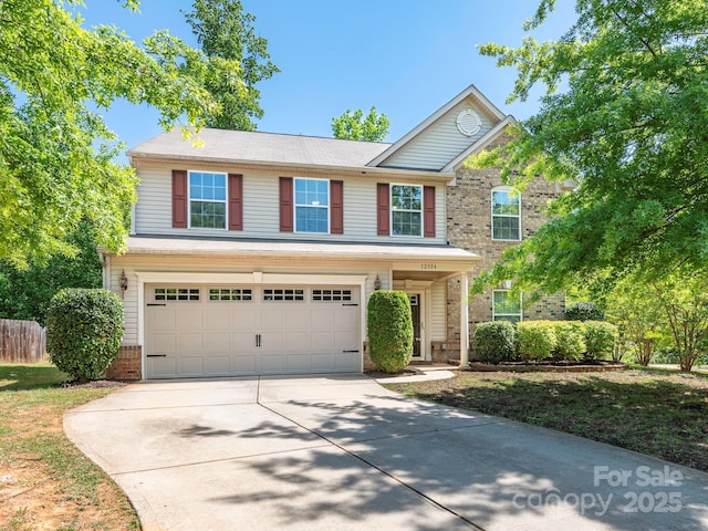 view of front of home featuring driveway, brick siding, an attached garage, and fence