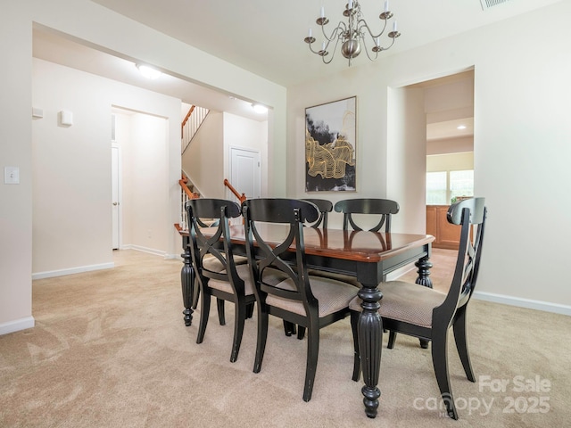 dining space featuring baseboards, a notable chandelier, light colored carpet, and stairway