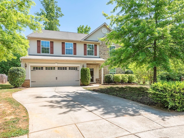 traditional-style house featuring driveway, brick siding, and an attached garage