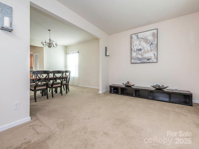 carpeted dining area featuring baseboards and an inviting chandelier