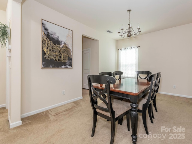dining room with baseboards, a chandelier, visible vents, and light colored carpet