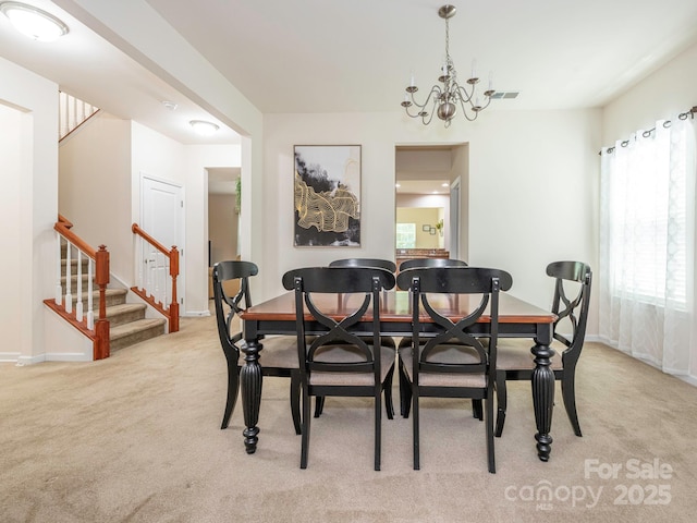 carpeted dining space with an inviting chandelier, visible vents, baseboards, and stairs