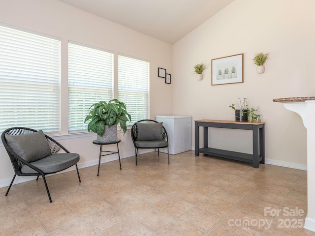 sitting room featuring baseboards and lofted ceiling