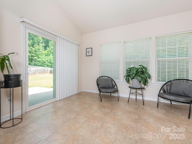 sitting room featuring vaulted ceiling and baseboards