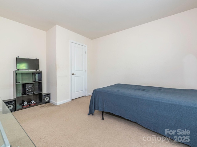 bedroom featuring baseboards and light carpet
