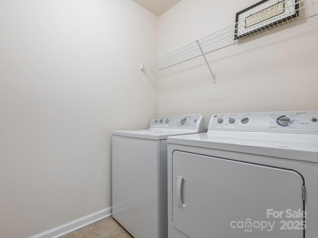 laundry area with separate washer and dryer, laundry area, baseboards, and light tile patterned flooring