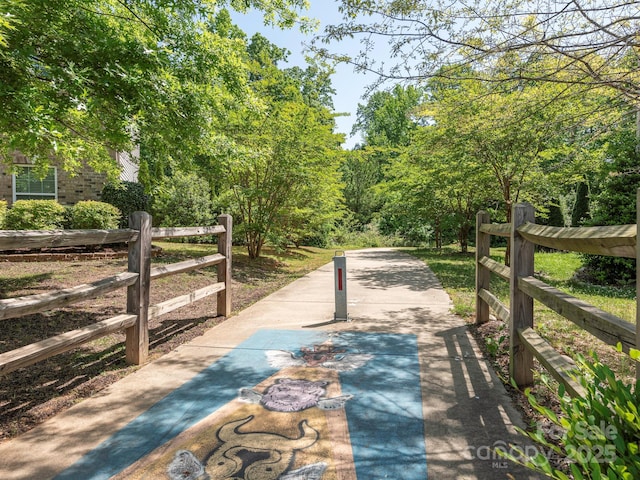 surrounding community featuring a forest view and fence