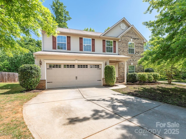 view of front of property with brick siding, fence, an attached garage, concrete driveway, and a front yard
