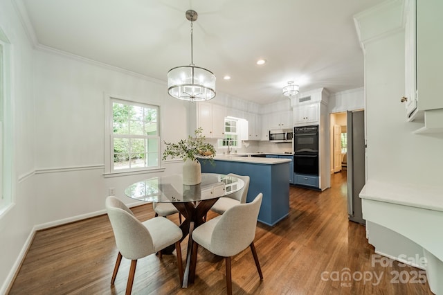dining space with recessed lighting, dark wood-style flooring, a chandelier, crown molding, and baseboards