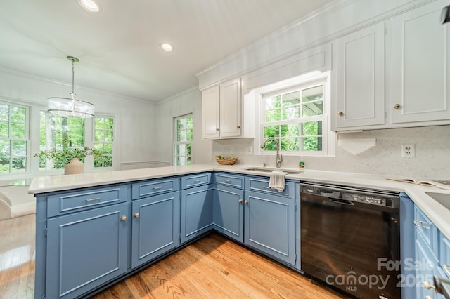 kitchen with black dishwasher, a sink, a peninsula, blue cabinetry, and ornamental molding