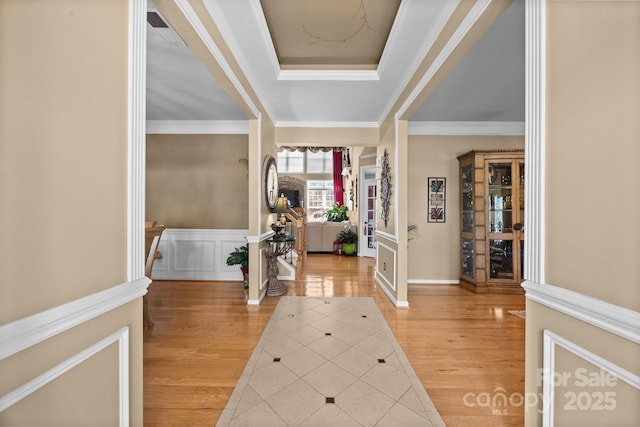 1900 Birchbrook Ct, Harrisburg, NC 28075 - foyer entrance featuring light wood-style floors, crown molding, a tray ceiling, a wainscoted wall, and a decorative wall