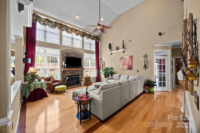 1900 Birchbrook Ct, Harrisburg, NC 28075 - living area featuring a stone fireplace, a ceiling fan, light wood-style flooring, high vaulted ceiling, and plenty of natural light