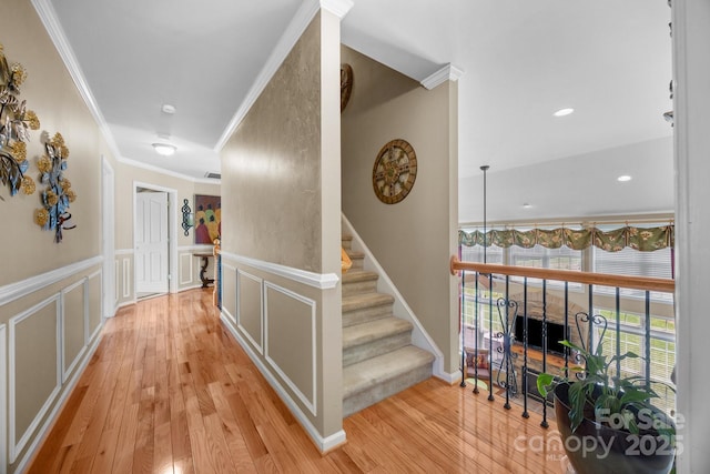 1900 Birchbrook Ct, Harrisburg, NC 28075 - hallway featuring crown molding, light wood-style flooring, wainscoting, a decorative wall, and stairs