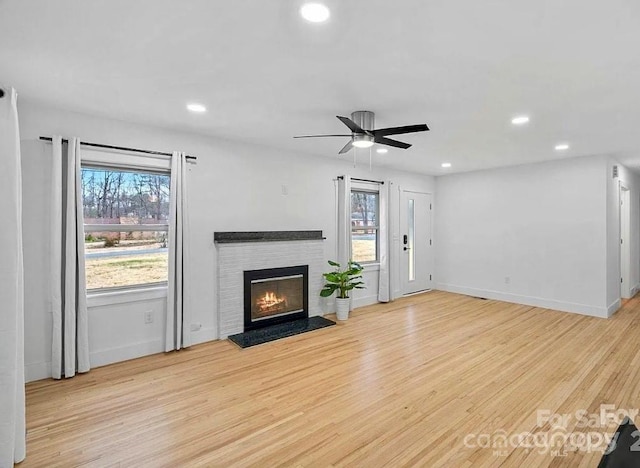 6301 Vernedale Rd, Charlotte, NC 28212 - unfurnished living room featuring light wood-style floors, plenty of natural light, a glass covered fireplace, and recessed lighting