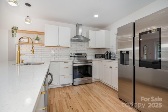 6301 Vernedale Rd, Charlotte, NC 28212 - kitchen featuring stainless steel appliances, wall chimney range hood, a sink, light countertops, and white cabinetry