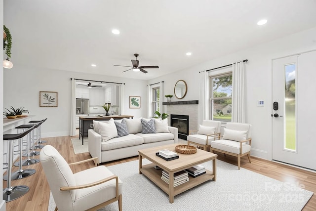 6301 Vernedale Rd, Charlotte, NC 28212 - living room with light wood finished floors, a ceiling fan, a glass covered fireplace, recessed lighting, and baseboards