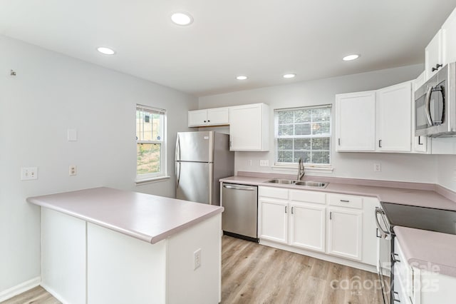 kitchen with a sink, appliances with stainless steel finishes, recessed lighting, and a peninsula