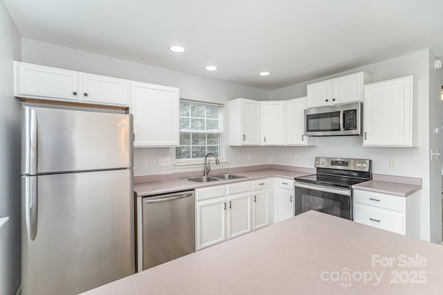 kitchen with recessed lighting, light countertops, white cabinets, a sink, and stainless steel appliances