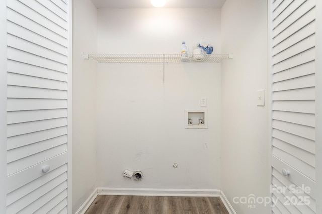 clothes washing area featuring washer hookup, dark wood-style flooring, electric dryer hookup, hookup for a gas dryer, and baseboards
