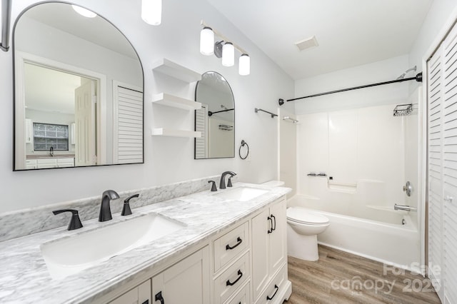 bathroom featuring toilet, visible vents, a sink, and wood finished floors