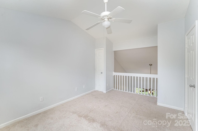unfurnished room featuring a ceiling fan, baseboards, vaulted ceiling, and carpet