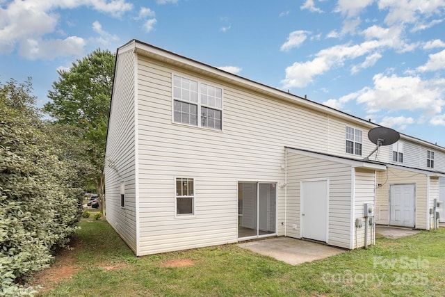 rear view of property featuring a lawn and a patio area