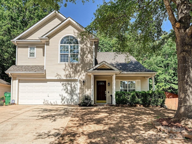 view of front of house featuring fence, driveway, a shingled roof, and a garage