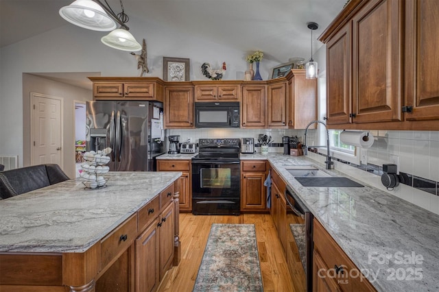 6084 Little River Ct, Granite Falls, NC 28630 - kitchen with black appliances, lofted ceiling, brown cabinetry, a sink, and light stone countertops