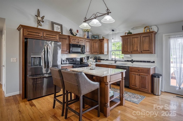 6084 Little River Ct, Granite Falls, NC 28630 - kitchen with stainless steel appliances, light wood-style flooring, a center island, pendant lighting, and a breakfast bar