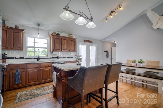 6084 Little River Ct, Granite Falls, NC 28630 - kitchen featuring a sink, lofted ceiling, light countertops, tasteful backsplash, and light wood-style floors