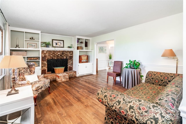 living room featuring a brick fireplace and wood finished floors
