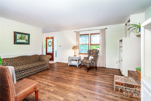 living area with visible vents and wood finished floors