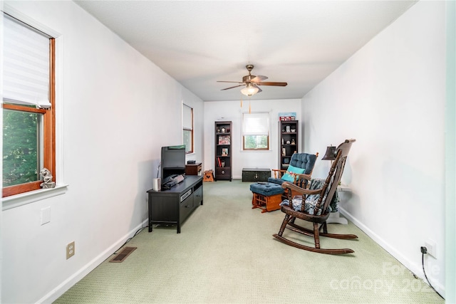 sitting room featuring baseboards, carpet, a ceiling fan, and visible vents