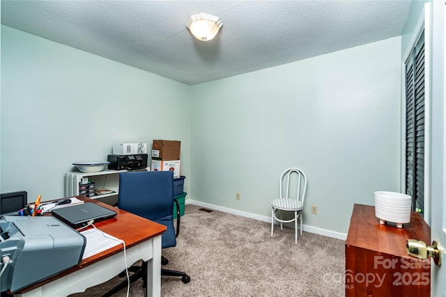 carpeted home office with baseboards and a textured ceiling