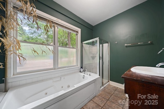bathroom with a whirlpool tub, a stall shower, vanity, and baseboards